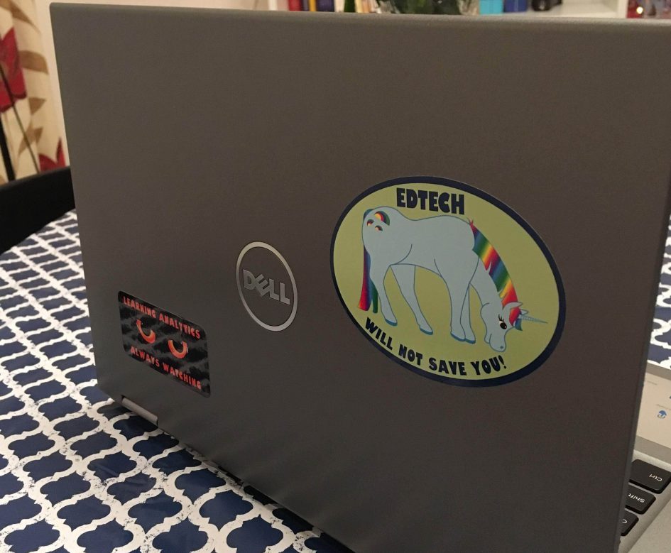 A photograph of Rosie's laptop with stickers. One showing the 'EdTech' unicorn with the text: EdTech will not save you and another sticker saying: Learning Analytics, always watching.